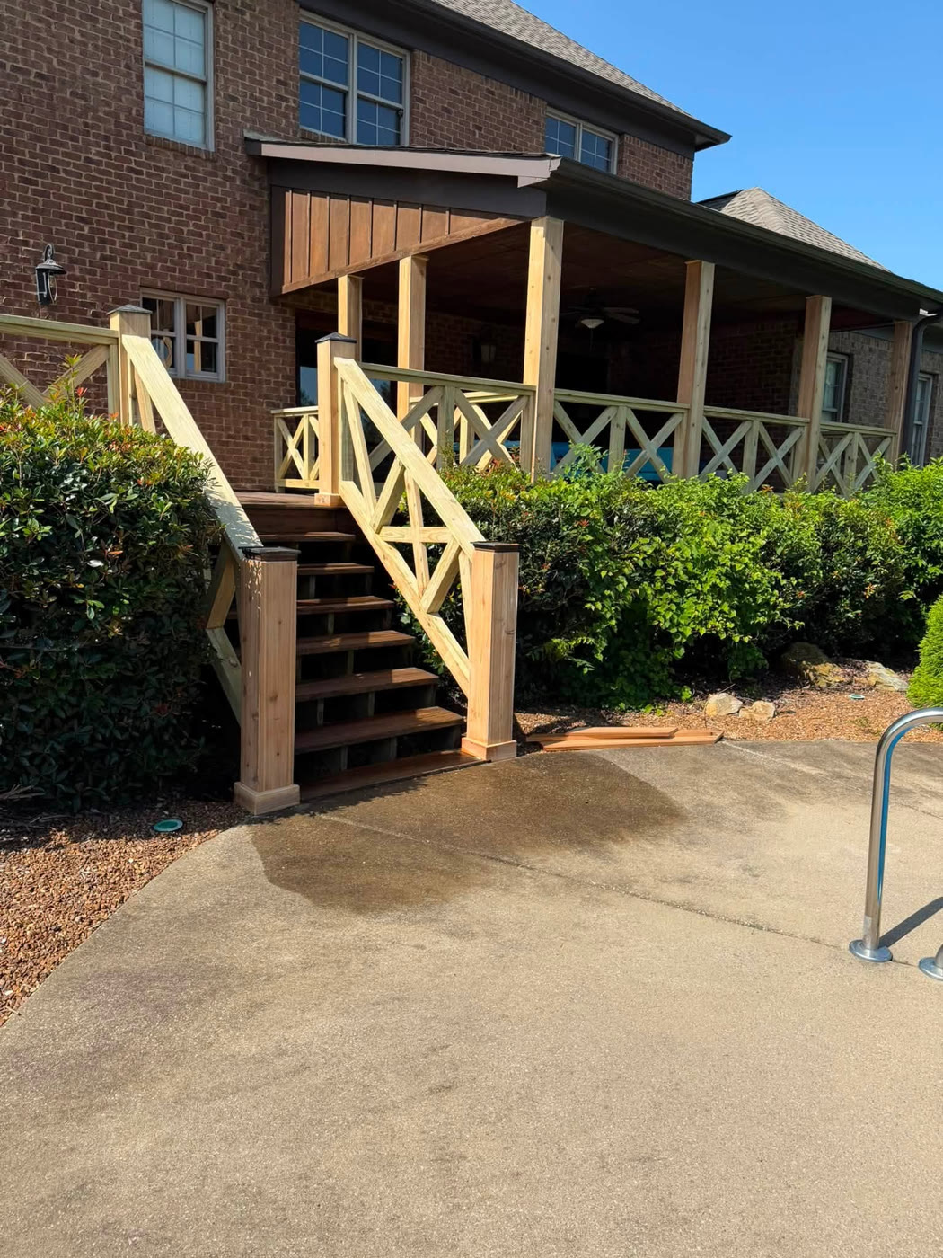 Wooden stairs and X-rail deck railing beside the pool